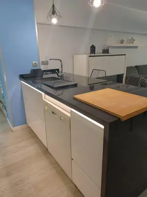 a kitchen with a black counter top with a sink at Alice Home in Puebla de Farnals