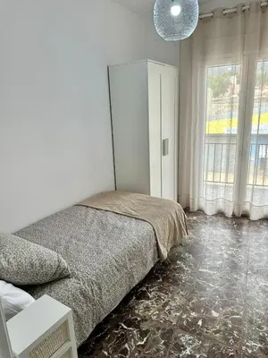 a bedroom with a bed and a large window at La Roca in Losa del Obispo
