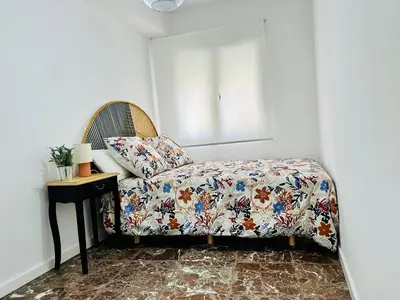 a bedroom with a bed and a table with a bedspread at La Roca in Losa del Obispo