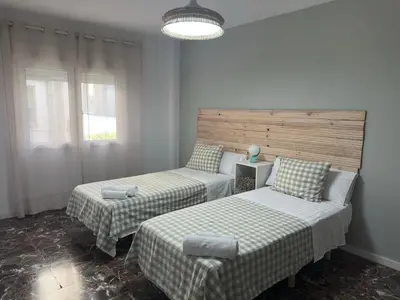 a room with two beds and a chair in it at La Roca in Losa del Obispo