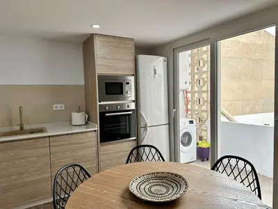a kitchen with a table and a refrigerator at La Roca in Losa del Obispo