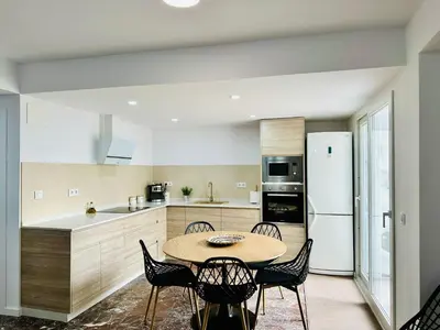 a kitchen with a table and chairs and a refrigerator at La Roca in Losa del Obispo