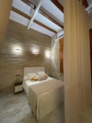 a bedroom with a bed and a brick wall at Dream Big with jacuzzi and terrace in Ruzafa in Valencia