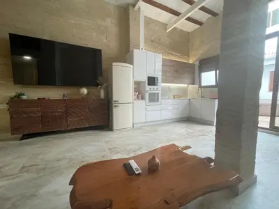 a large kitchen with a table and a tv on the wall at Dream Big with jacuzzi and terrace in Ruzafa in Valencia