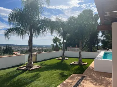 a yard with palm trees and a swimming pool at Villa con piscina en la montaña in Llombay