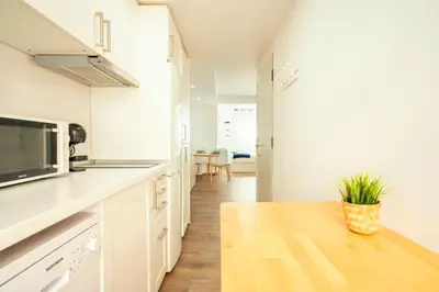 a kitchen with white cabinets and a wooden table at Apto 2 P Ferrandis in Valencia