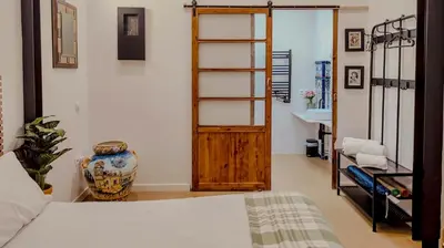 a bedroom with a bed and a wooden door at casa del Cabanyal La Playa in Valencia