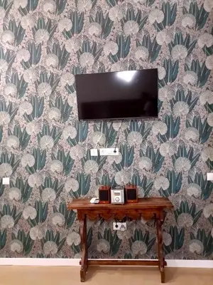 a flat screen tv on a wall with a table at casa del Cabanyal La Playa in Valencia