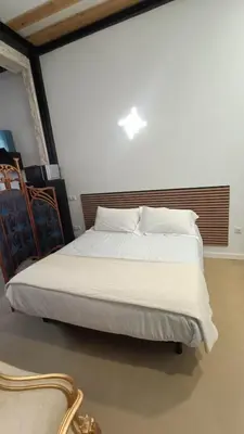 a bedroom with a large bed with white sheets at casa del Cabanyal La Playa in Valencia