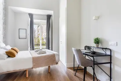a bedroom with a bed and a desk and a chair at Valencia City Apartment with Gym Pool Free Parking TheHavenEscape in Valencia