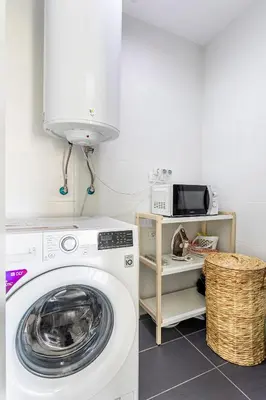 a laundry room with a washing machine and a microwave at Valencia City Apartment with Gym Pool Free Parking TheHavenEscape in Valencia