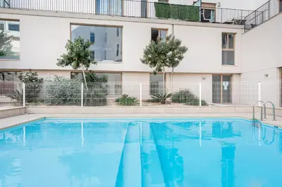 a swimming pool in front of a building at Valencia City Apartment with Gym Pool Free Parking TheHavenEscape in Valencia