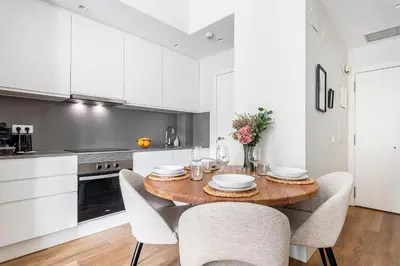 a kitchen with a wooden table and white cabinets at Valencia City Apartment with Gym Pool Free Parking TheHavenEscape in Valencia