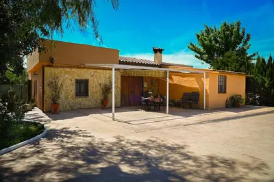 a house with a patio with a table and chairs at Valencia Autentica, Casa Rural 