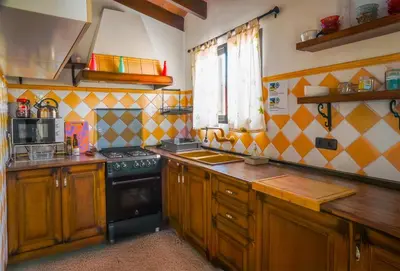 a kitchen with wooden cabinets and a black stove at Valencia Autentica, Casa Rural 