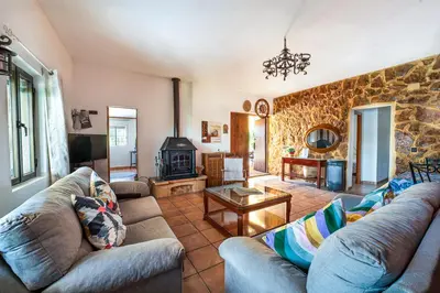 a living room with couches and a stone wall at Valencia Autentica, Casa Rural 
