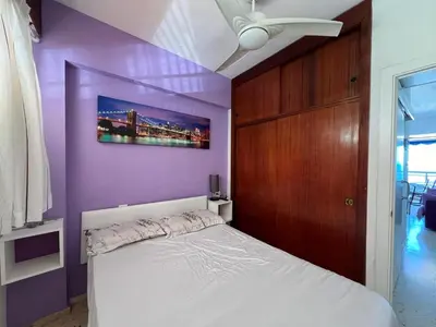a purple bedroom with a bed and a ceiling fan at El Prado - Primera Línea Playa Cullera in Valencia