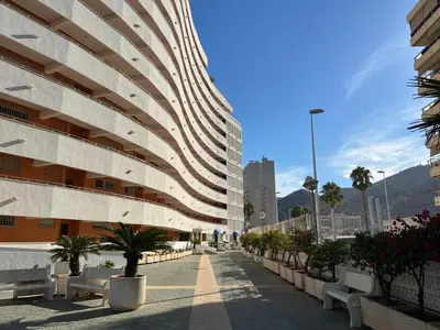 a building with benches in front of a building at El Prado - Primera Línea Playa Cullera in Valencia