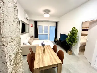a room with a bed and a table and a couch at Convenient, Charming Apartment 15 Mins from City Center in Valencia
