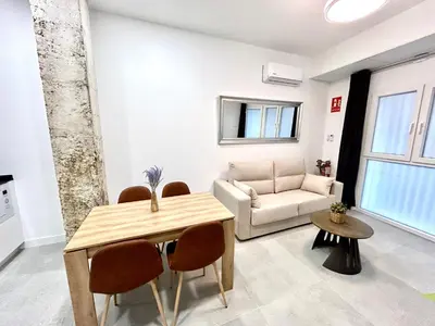 a living room with a table and a couch at Convenient, Charming Apartment 15 Mins from City Center in Valencia