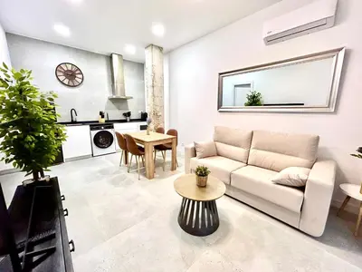 a living room with a couch and a table at Convenient, Charming Apartment 15 Mins from City Center in Valencia