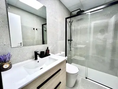 a bathroom with a sink and a glass shower at Valencia Urban Escape Comfort Meets Luxury, 4 Ppl in Valencia