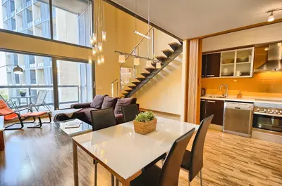 a kitchen and living room with a table and chairs at Ohmyloft Valencia in Burjasot