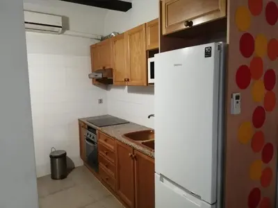 a kitchen with a white refrigerator and wooden cabinets at Apartamento Gutenberg in Valencia