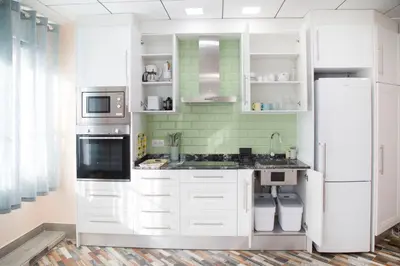 a kitchen with white cabinets and a refrigerator at District Key - Carricola in Valencia