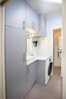 a white laundry room with a sink and a washing machine at District Key - Carricola in Valencia