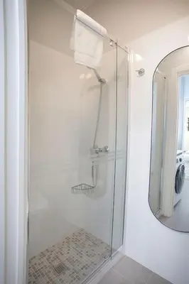 a shower with a glass door and a mirror at District Key - Carricola in Valencia