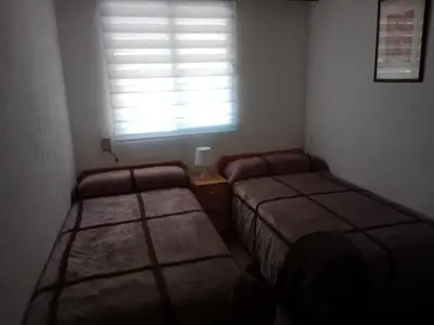 two beds in a small room with a window at Los Olivos BB1 in Faro de Cullera