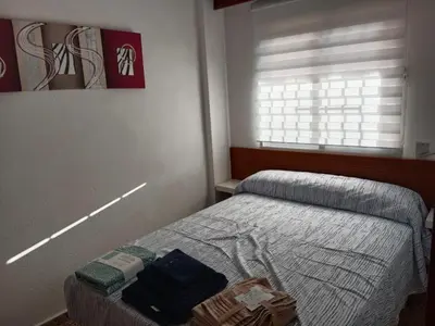 a small bedroom with a bed and a window at Los Olivos BB1 in Faro de Cullera