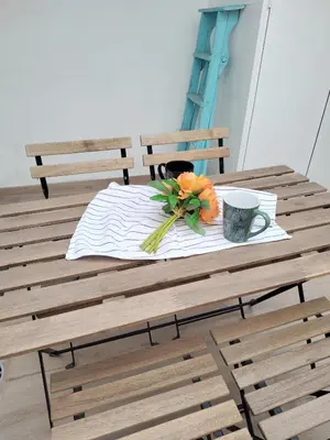 a wooden table with a coffee mug and flowers on it at Maravillosa casa junto al mar y cerca del centro in Valencia