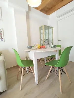 a white table with green chairs in a room at Maravillosa casa junto al mar y cerca del centro in Valencia