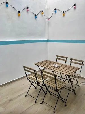a wooden table and chairs with lights on a wall at Maravillosa casa junto al mar y cerca del centro in Valencia