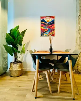 a dining room table with chairs and a painting on the wall at ORI B Nice & Spacious Flat Close to the Center in Valencia