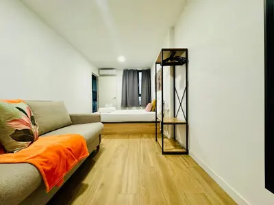 a living room with a couch and a bedroom at ORI B Nice & Spacious Flat Close to the Center in Valencia