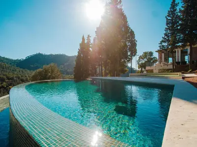 a swimming pool with the sun in the background at Alojamiento Rural 1Respiro Parque Natural Serra Calderona in Serra