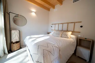 a bedroom with a bed with a wooden head board at Alojamiento Rural 1Respiro Parque Natural Serra Calderona in Serra