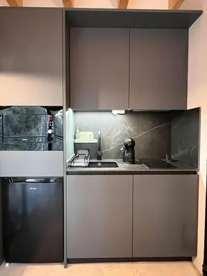 a kitchen with gray cabinets and a refrigerator at Alojamiento Rural 1Respiro Parque Natural Serra Calderona in Serra