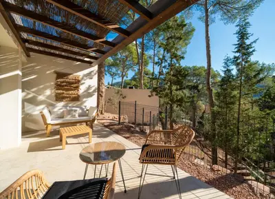 a patio with chairs and tables and a couch at Alojamiento Rural 1Respiro Parque Natural Serra Calderona in Serra