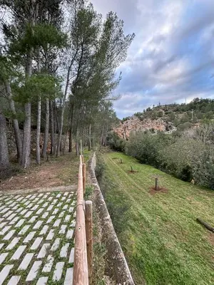 a wooden fence next to a field with trees at Paraiso Natural Unico -Villa Cueva Turche in Valencia