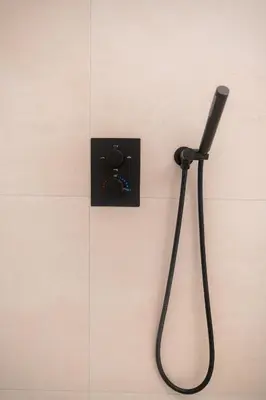 a black shower head hanging on a wall at Green Luxury Zamenhof in Valencia