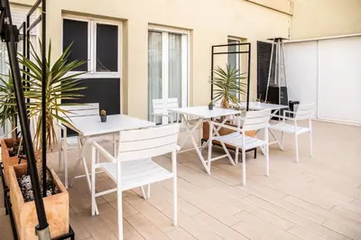 a room with white tables and chairs and windows at Zalamera BnB in Valencia