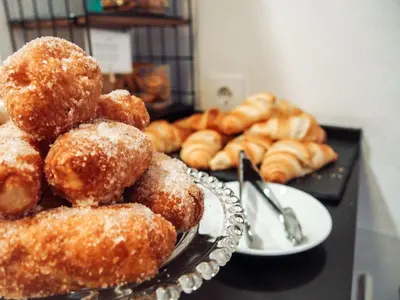 a pile of donuts on a table with plates of donuts at Zalamera BnB in Valencia