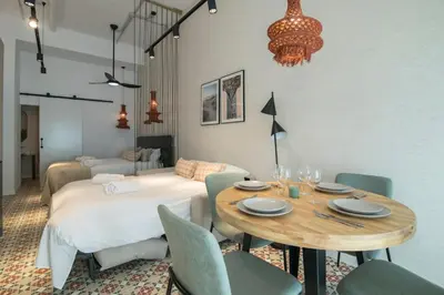 a dining room with a table and a bed at District Key - Valencia, Olimpia 2 in Valencia