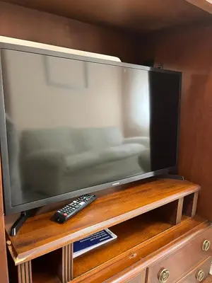 a flat screen tv on a wooden stand with a remote control at Casa Roma in Casinos