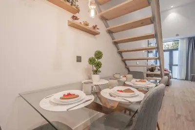 a dining room with a glass table and a staircase at Suite Guillem Jáfer - Roig Arena in Valencia