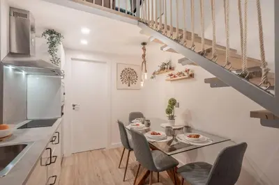 a kitchen with a table and chairs and a staircase at Suite Guillem Jáfer - Roig Arena in Valencia